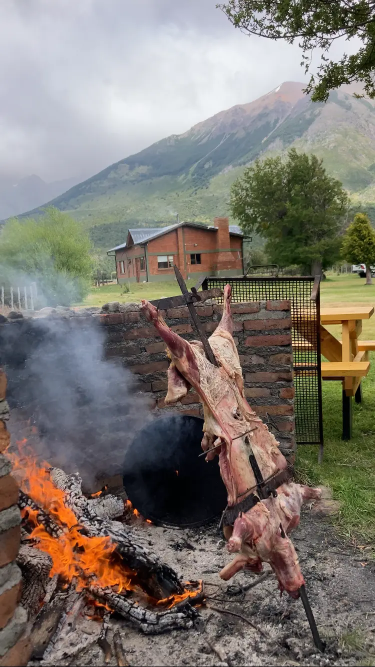 Cordero al asador frente a Refugio Cordillerano y la montaña
