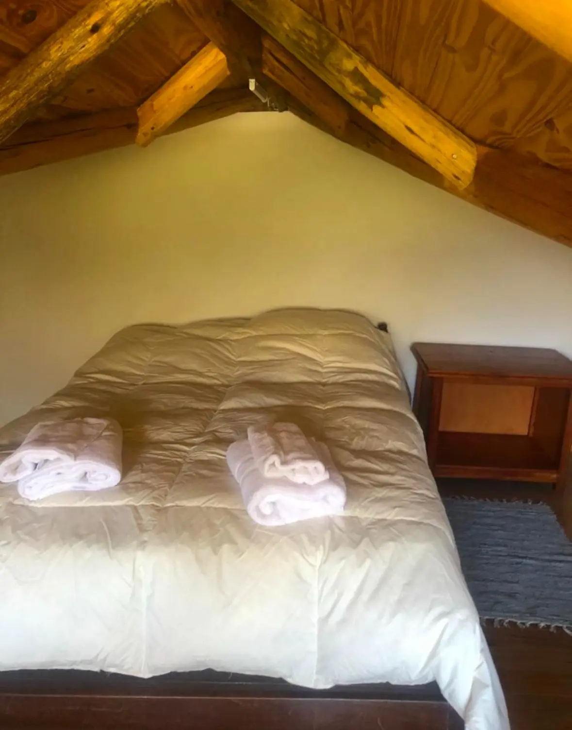 Dormitorio doble en el altillo con ropa blanca preparada