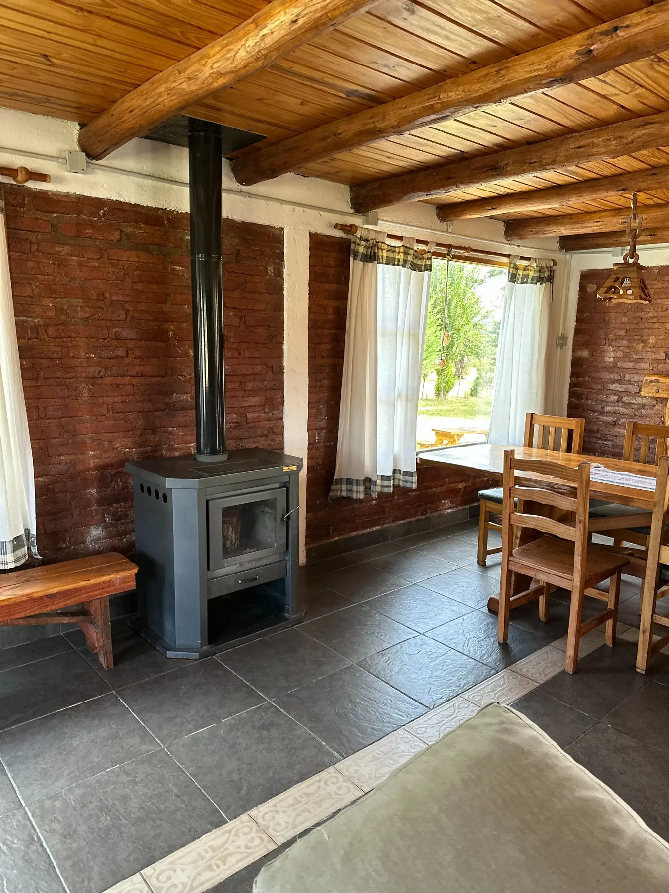 Living comedor cálido con estufa a leña y vigas de madera